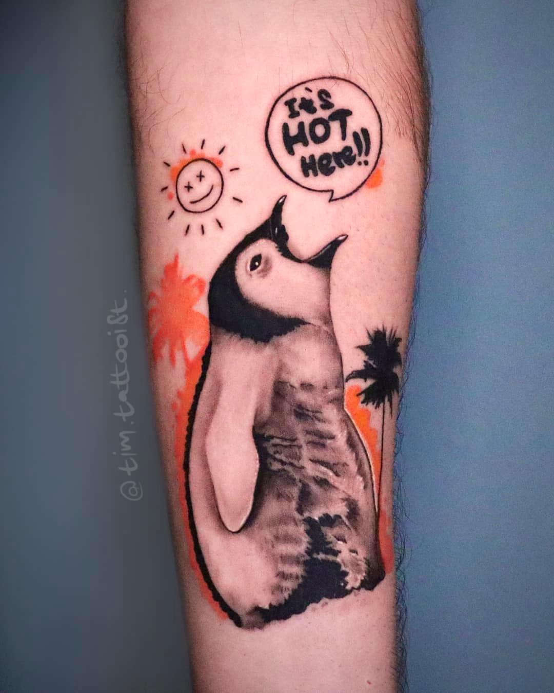 Tattoo penguin on the forearm in style realism